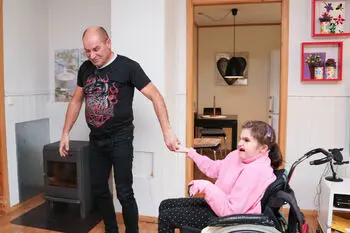 En mann som leier en jente i rullestol