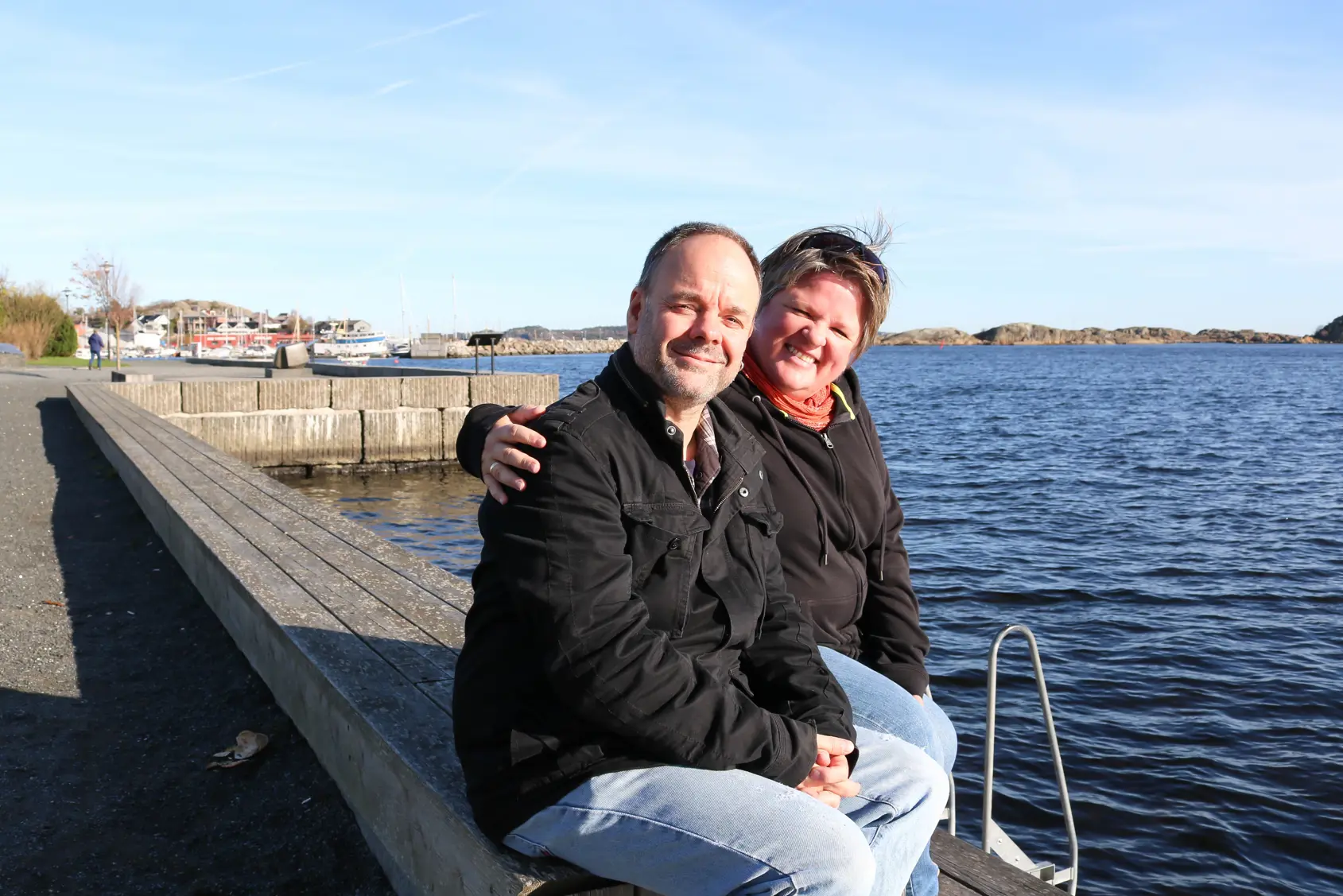 En mann og kvinne som sitter sammen på kaikanten