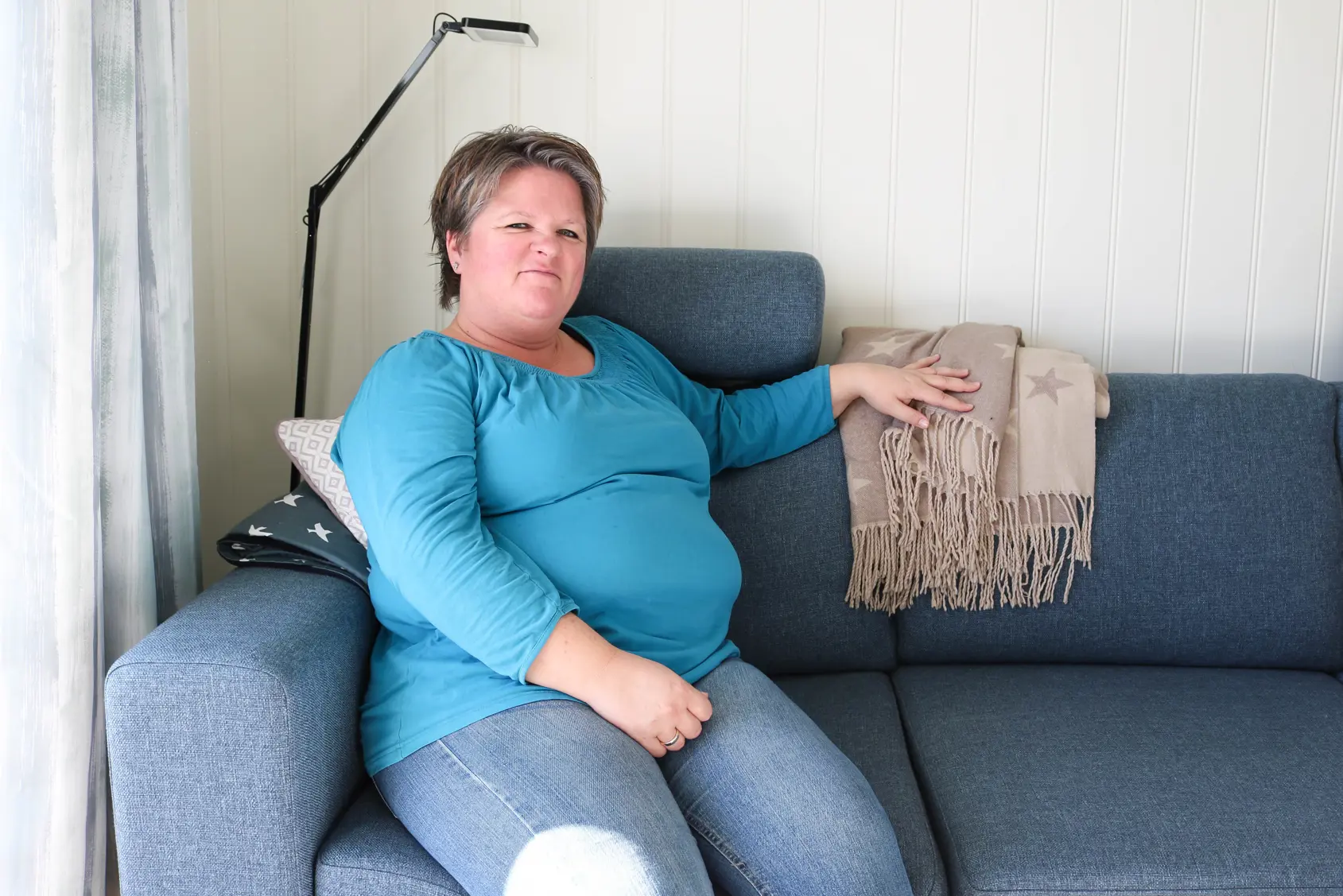 En kvinne som sitter på en sofa