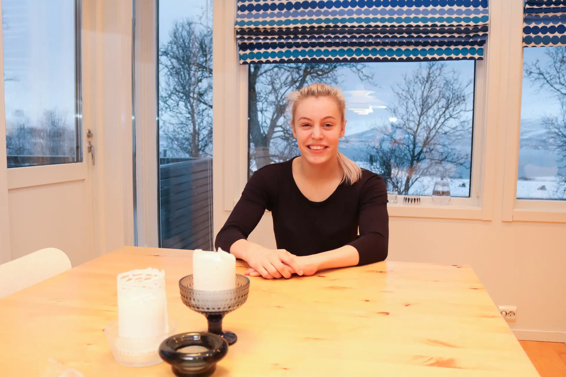 Ung lyshåret kvinne som sitter ved et bord