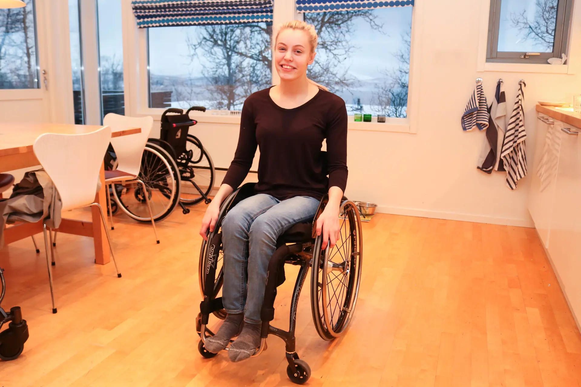 Lyshåret ung kvinne som sitter i rullestol