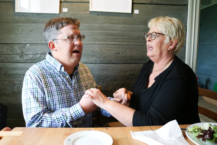 En mann og en kvinne som sitter ved et bord og spiser mat