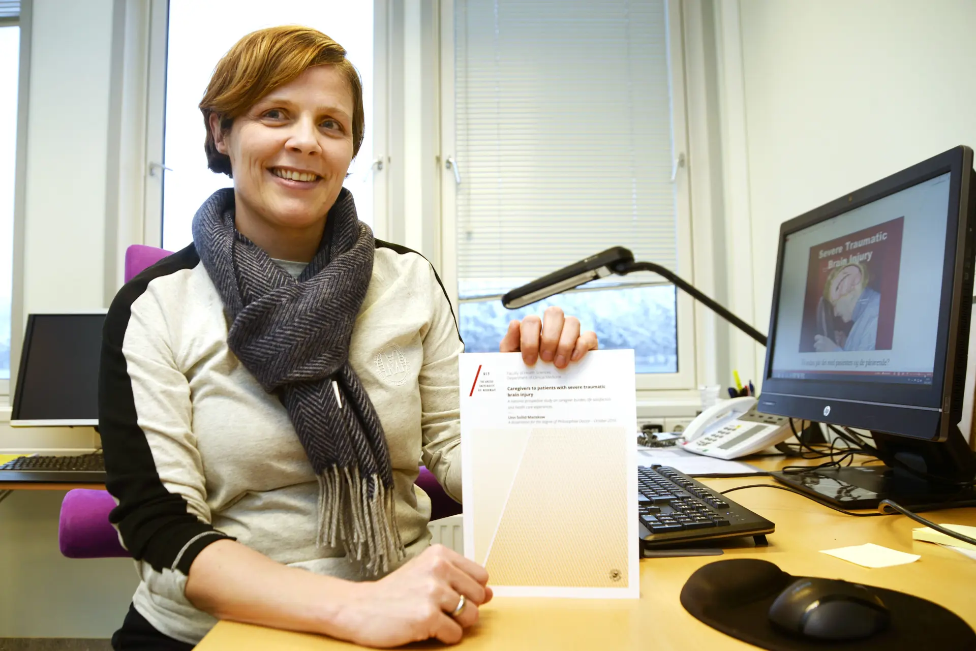 Kvinne poserer med diplom