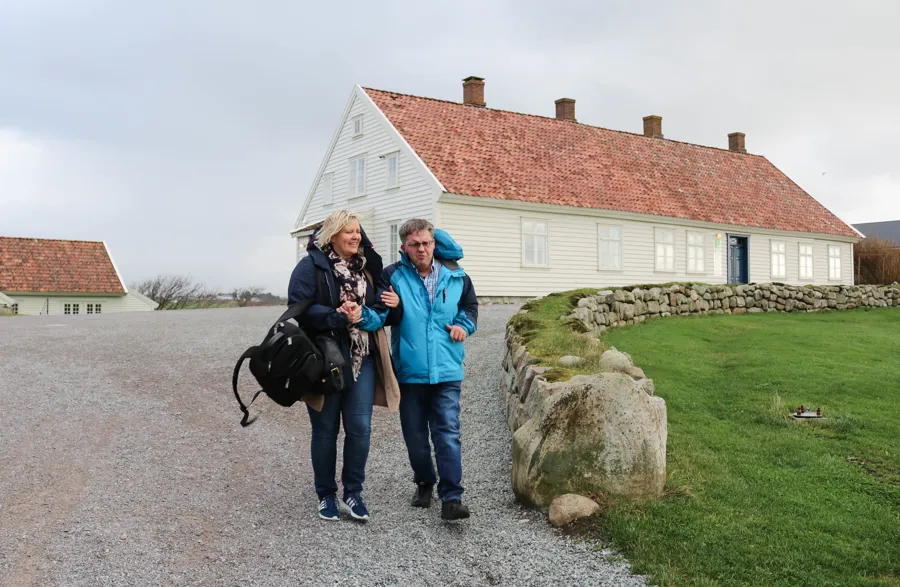 En gruppe mennesker som poserer for kameraet foran et hus