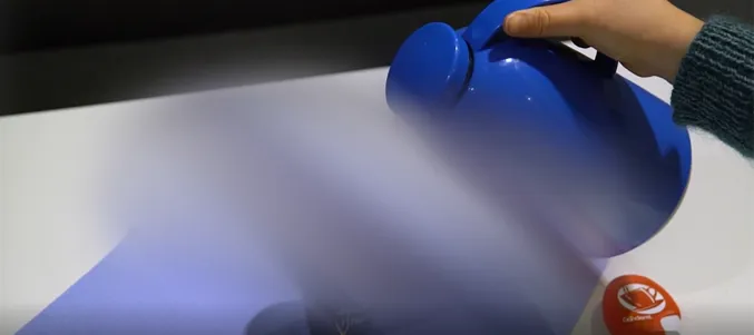 En hånd som holder en blå plastflaske