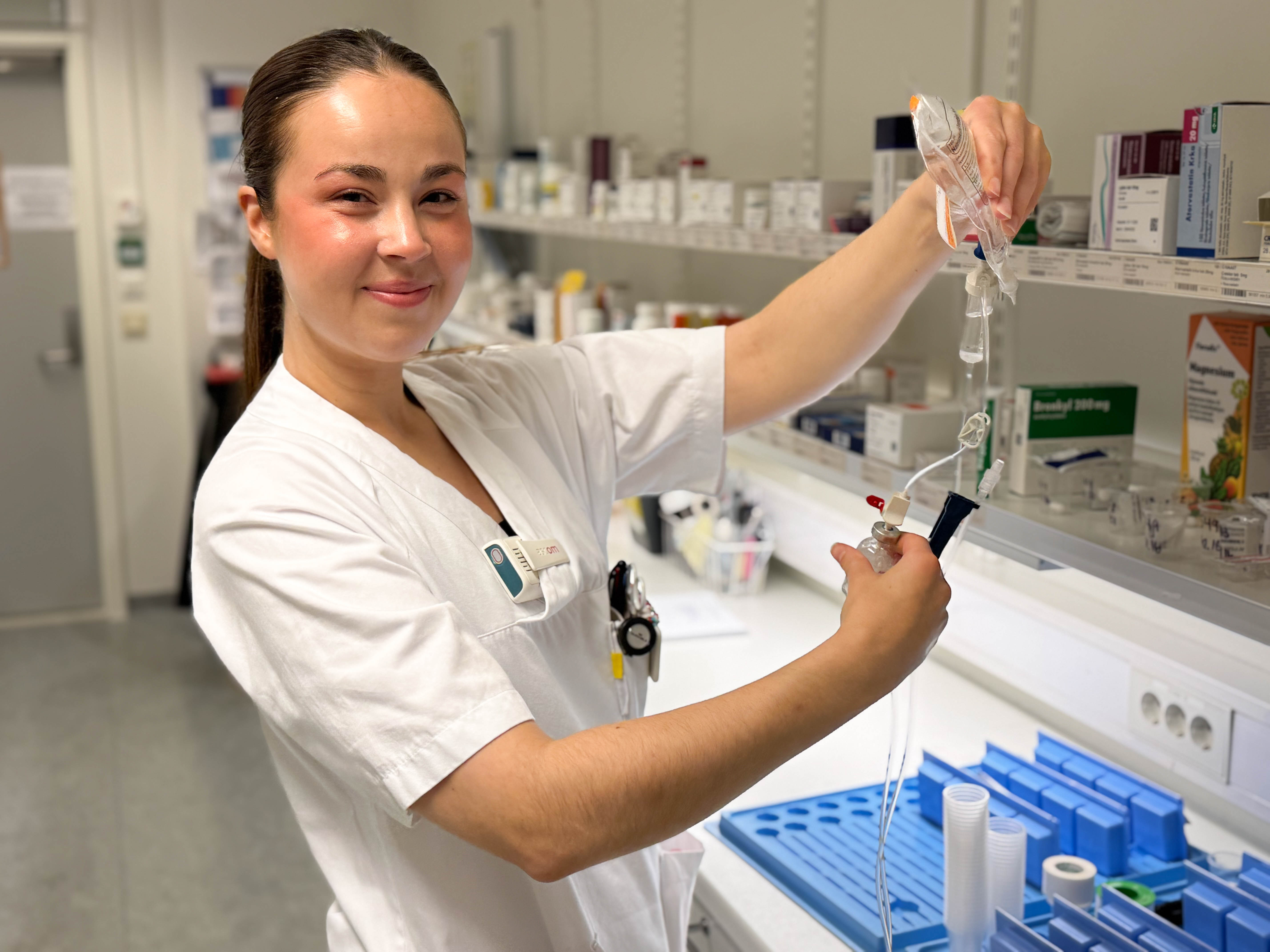 En mann i laboratoriefrakk som holder et beger