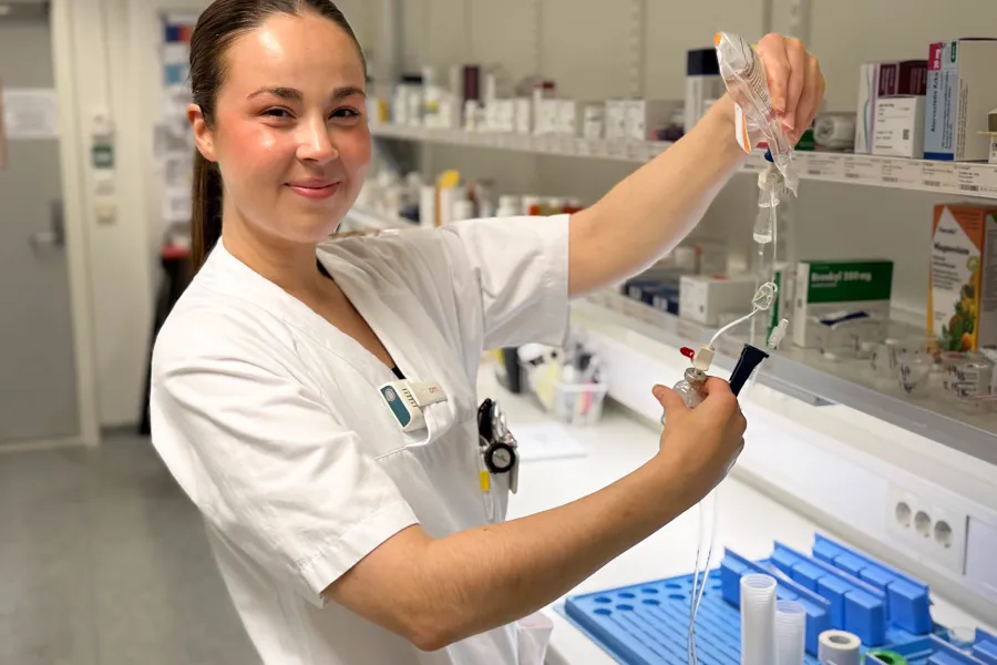 En mann i laboratoriefrakk som holder et beger