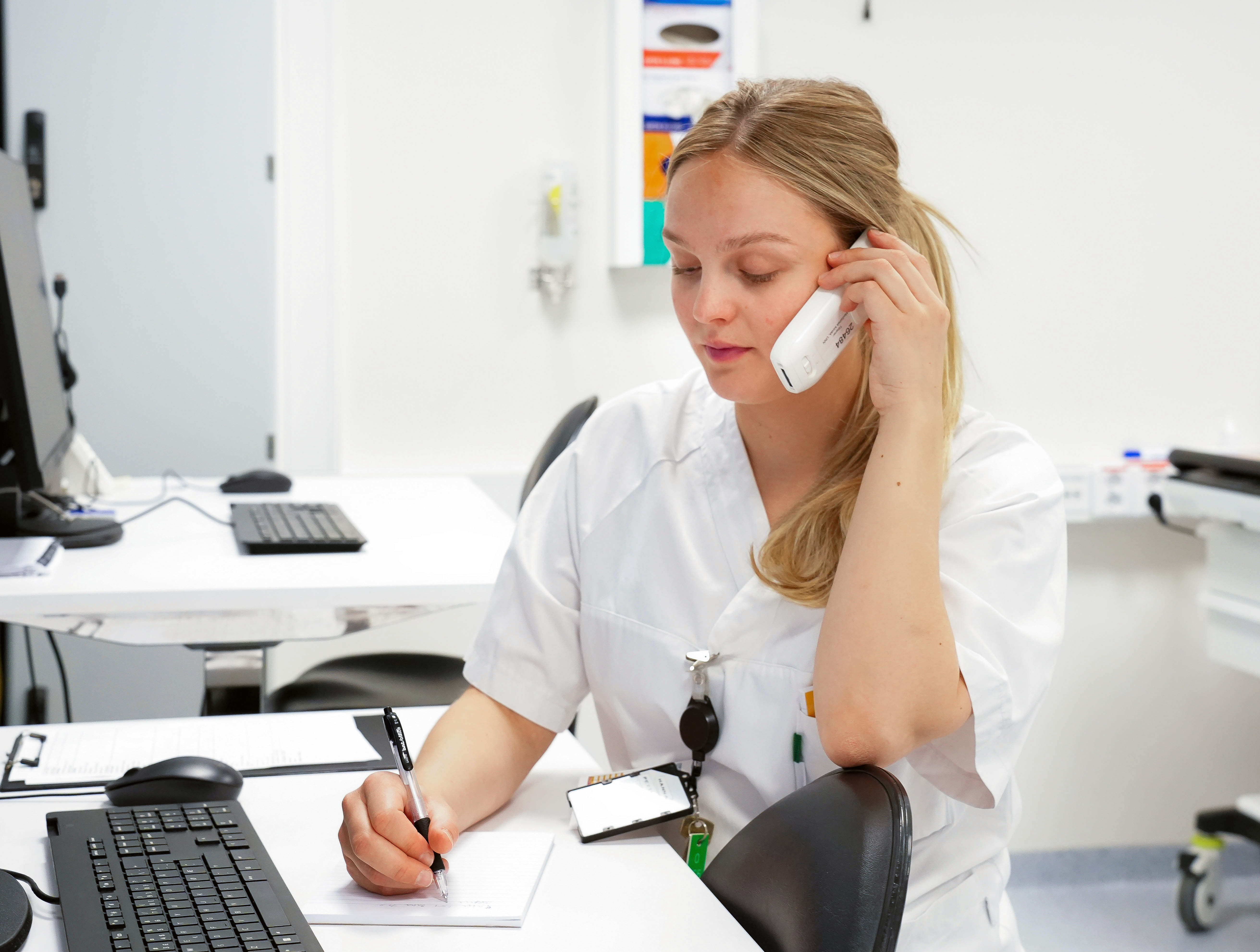 En person som sitter ved et skrivebord med headset på
