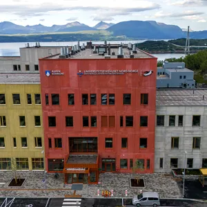 En gruppe bygninger med fjell i bakgrunnen