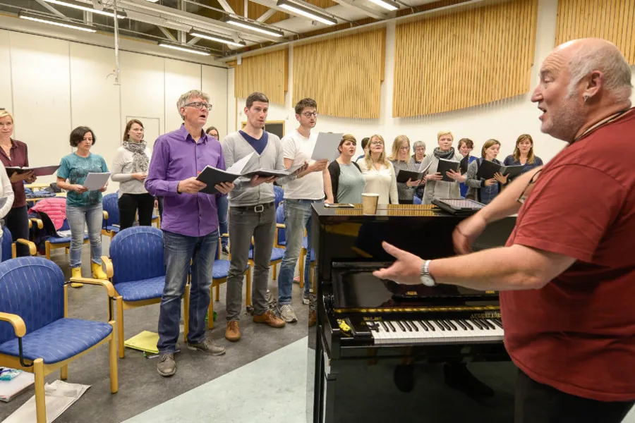 En gruppe mennesker som spiller piano