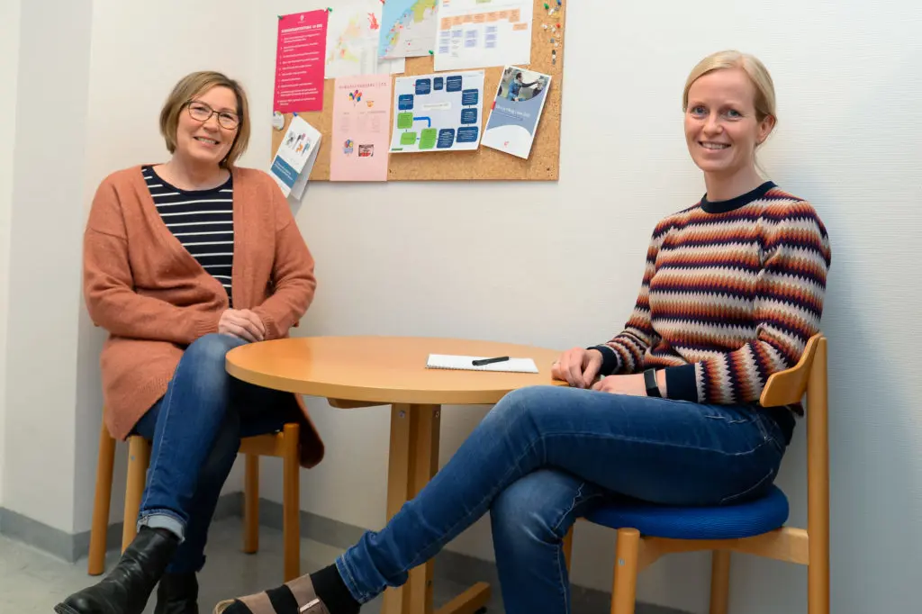 Et par kvinner som sitter ved et bord