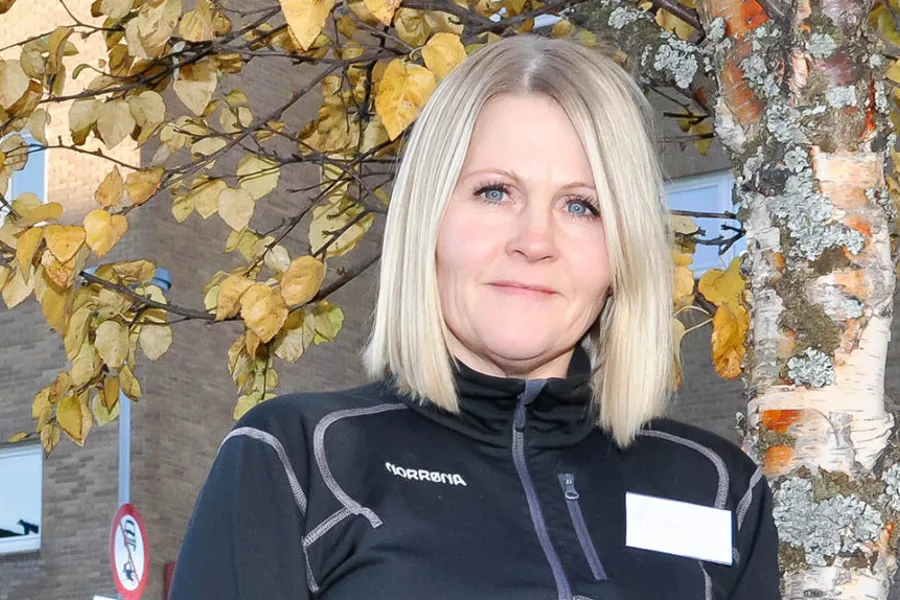 En person som står foran et tre med gule blader