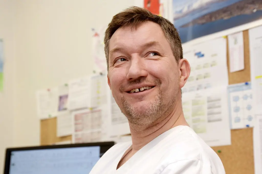 En mann som smiler til kameraet