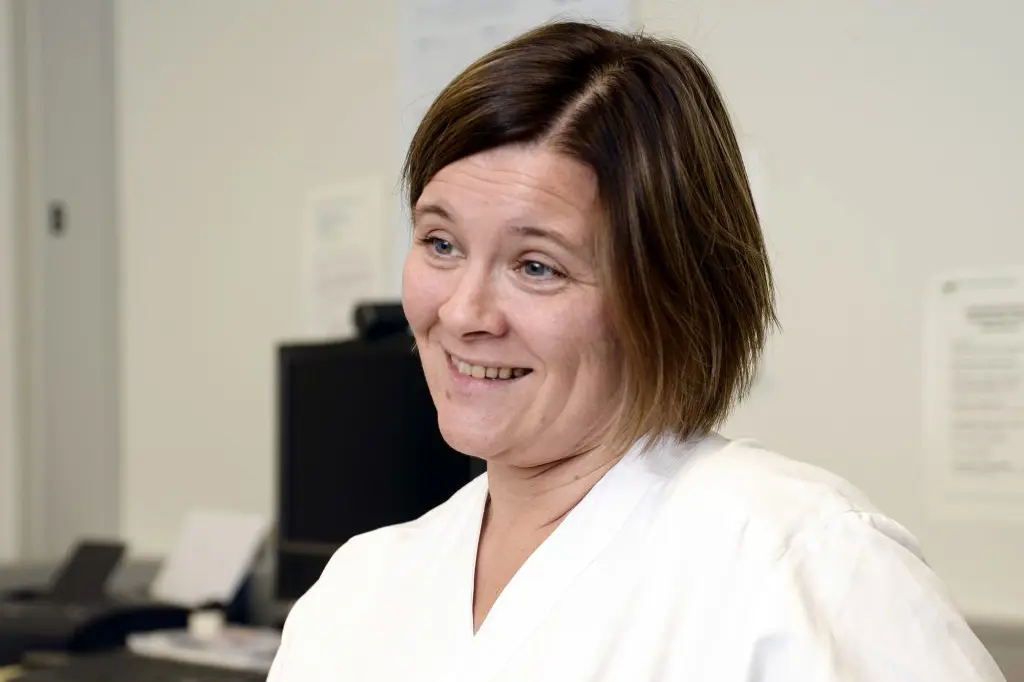 En kvinne som smiler til kameraet