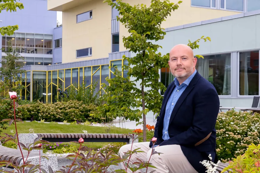 En mann som sitter på en stol utenfor