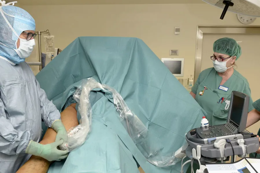 Kirurg Lars Knutson ved UNN Narvik er i gang med laseroperasjonen, og benytter ultralyd som nødvendig hjelpemiddel for å kvalitetssikre inngrepet. Spesialsykepleier Tove Birkeland følger med til høyre mens hun passer på pasienten. Foto: Per-Christian Johansen