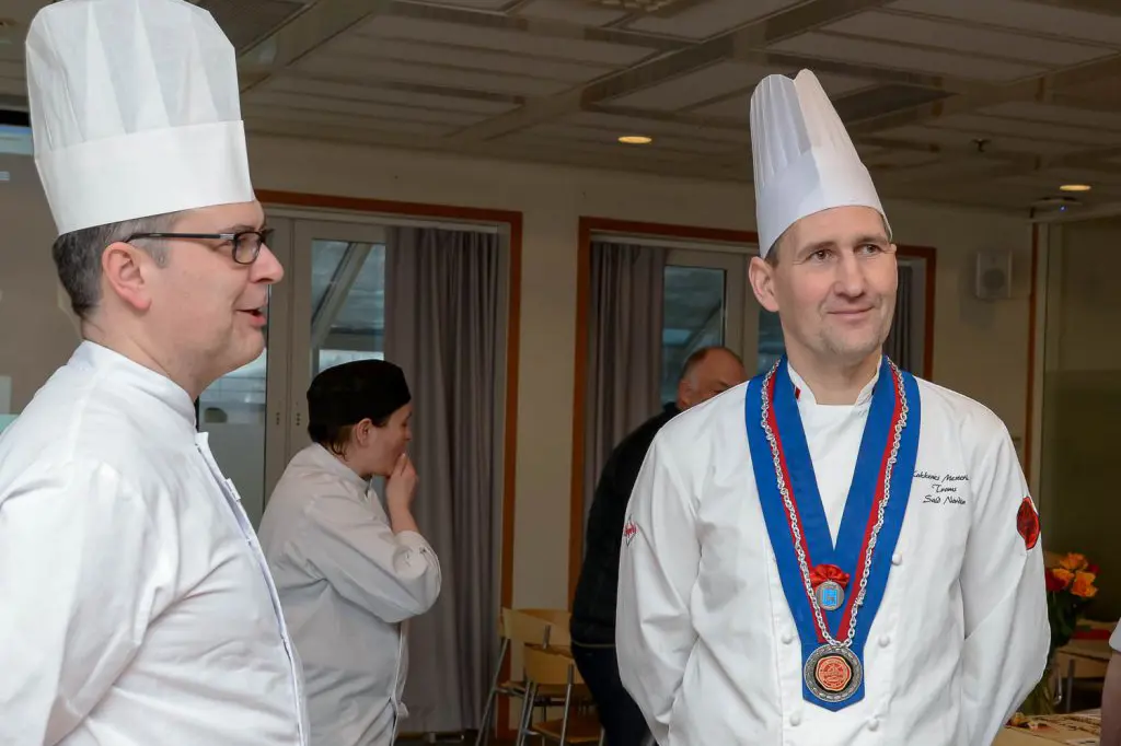 En person som har på seg kokkehatt og en person som har på seg kokkeuniform