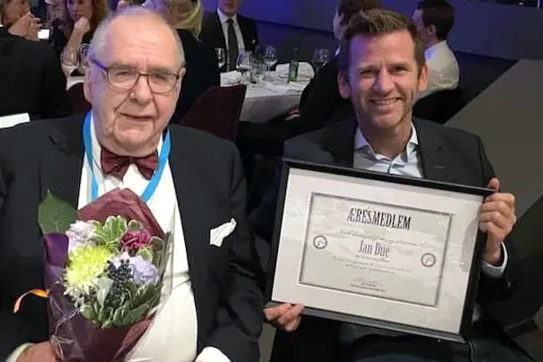 En person som holder et skilt og en person som holder en blomsterbukett