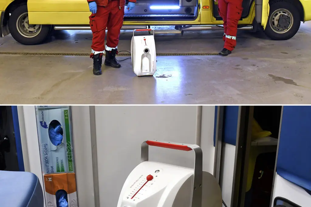Et par menn i oransje jumpsuits som står ved siden av en hvit maskin