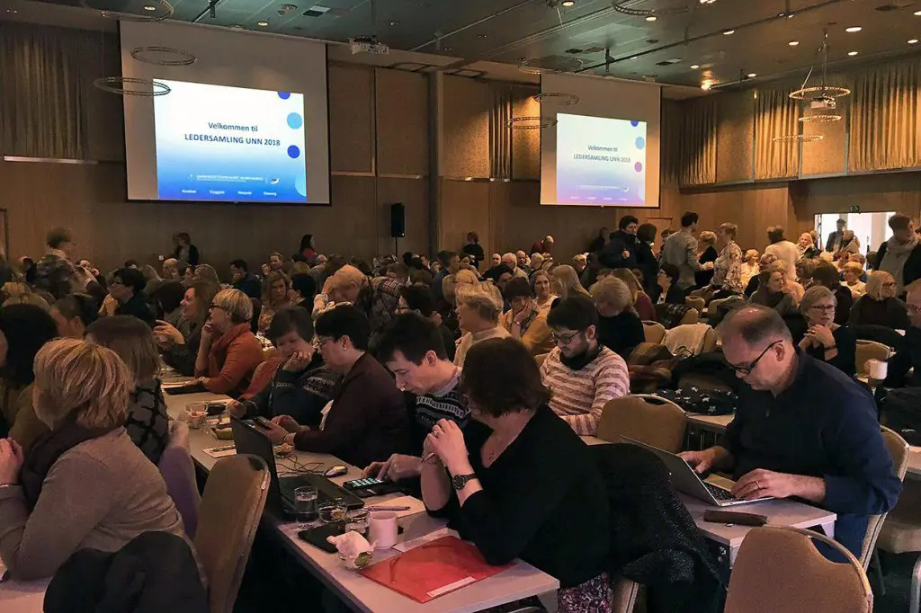 En gruppe mennesker som sitter i et konferanserom