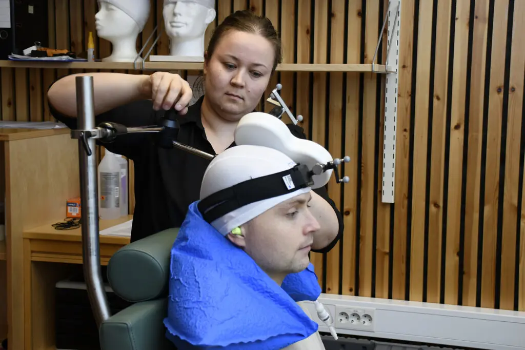En person med maske på hodet ved siden av en person med pistol