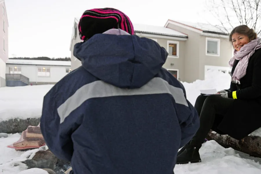 En person som sitter på en bil med et teppe på ryggen