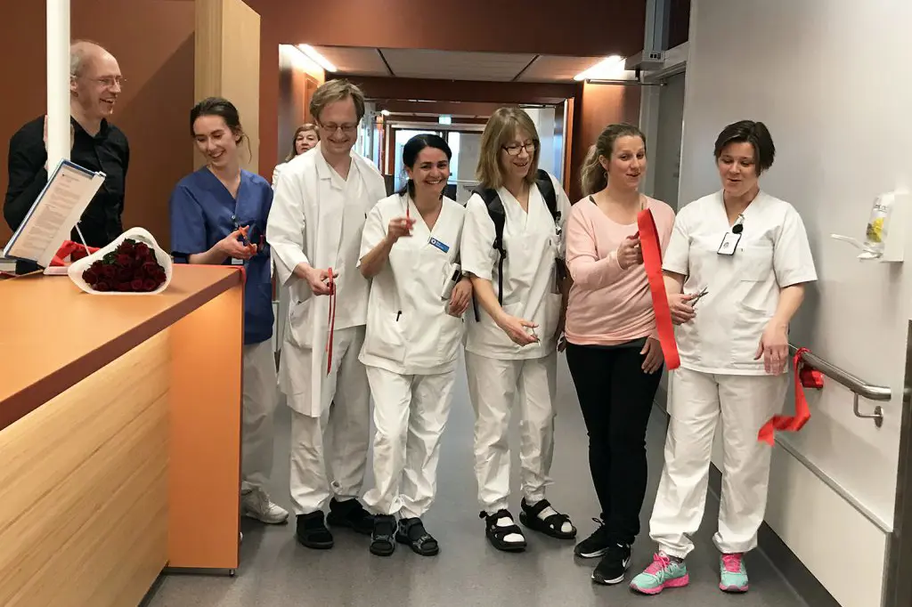 En gruppe mennesker i hvite laboratoriefrakker som står i et rom