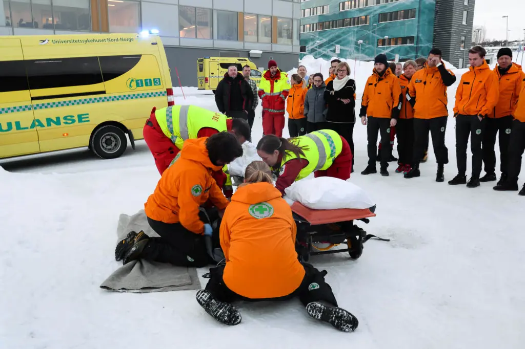 En gruppe mennesker i oransje jakker