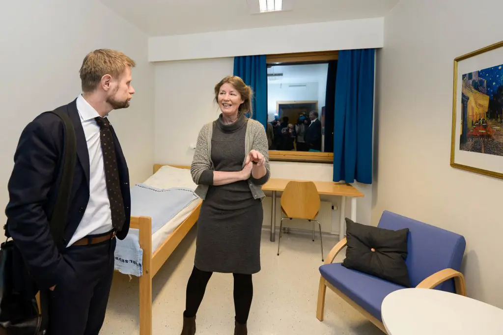 En mann og en kvinne i et rom med seng og stoler