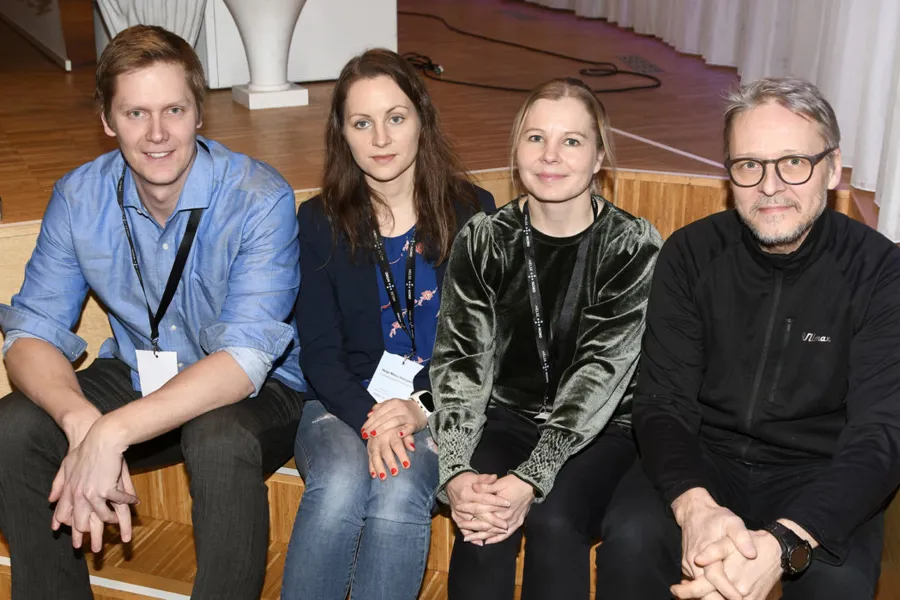 En gruppe mennesker som sitter sammen og smiler