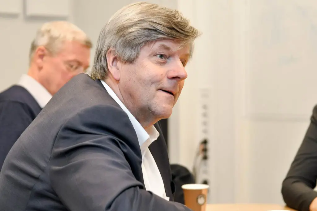 En person i dress som sitter ved et bord