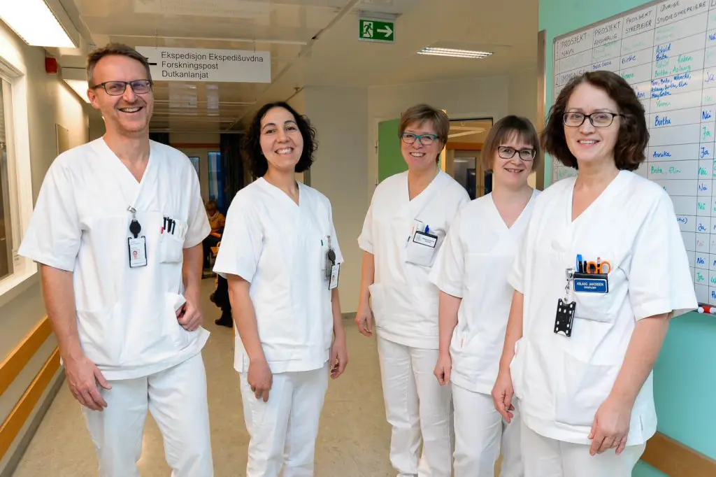 En gruppe mennesker iført hvite laboratoriefrakker