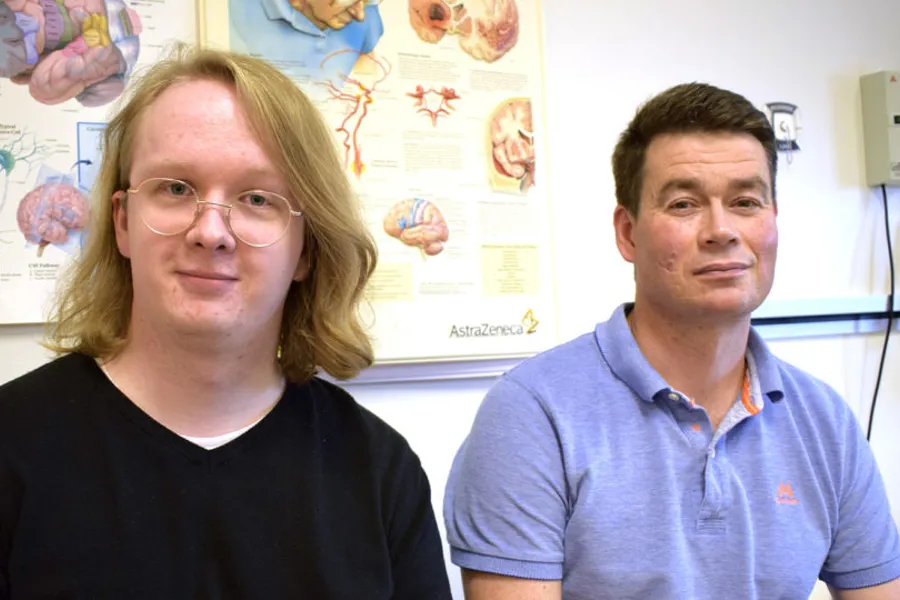 En mann og en kvinne i et rom med plakater på veggen