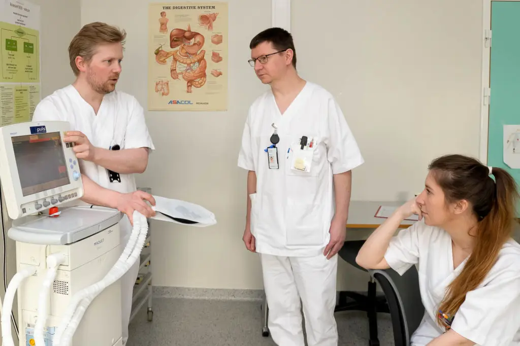 En gruppe mennesker i hvite laboratoriefrakker som ser på et papir