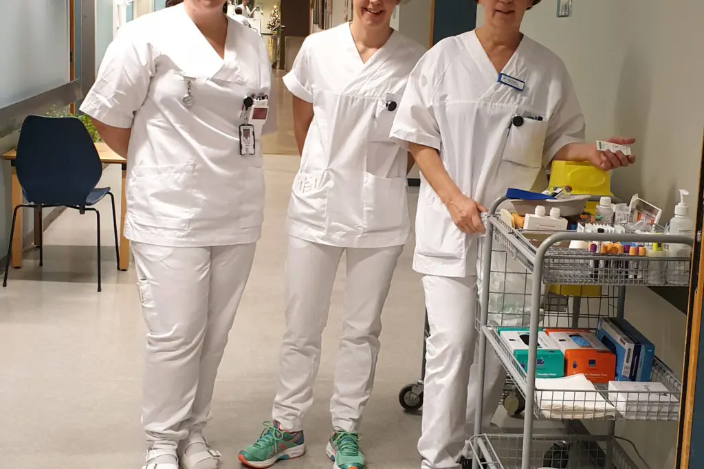 En gruppe mennesker i hvite laboratoriefrakker som står i et rom