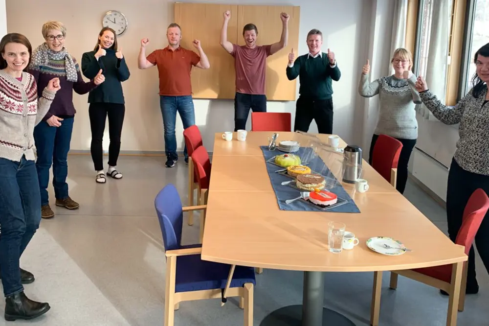 En gruppe mennesker som står rundt et bord med mat på