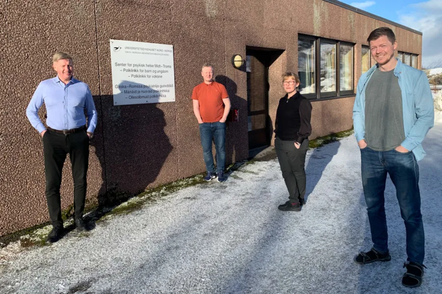 En gruppe mennesker som står utenfor en bygning