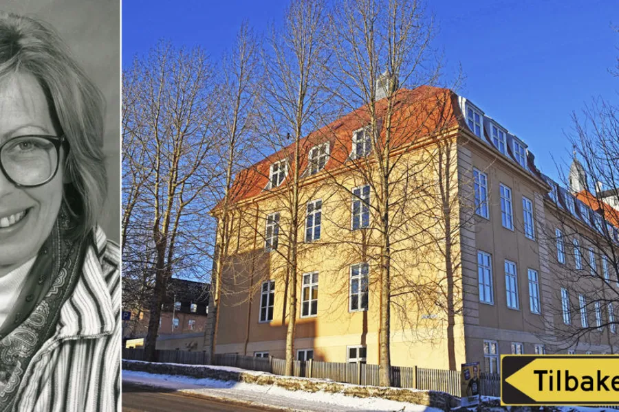 En person som smiler foran en bygning