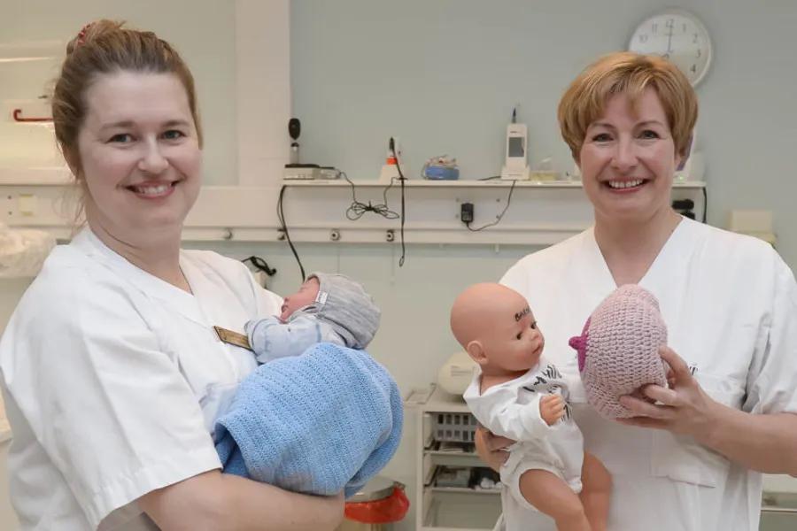 Et par kvinner som holder en baby