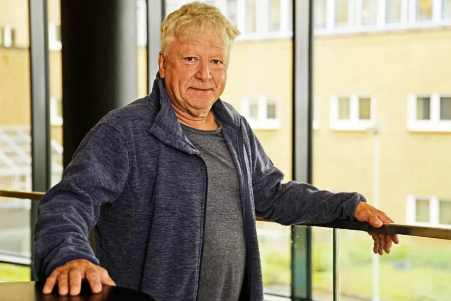 En mann som lener seg mot et vindu