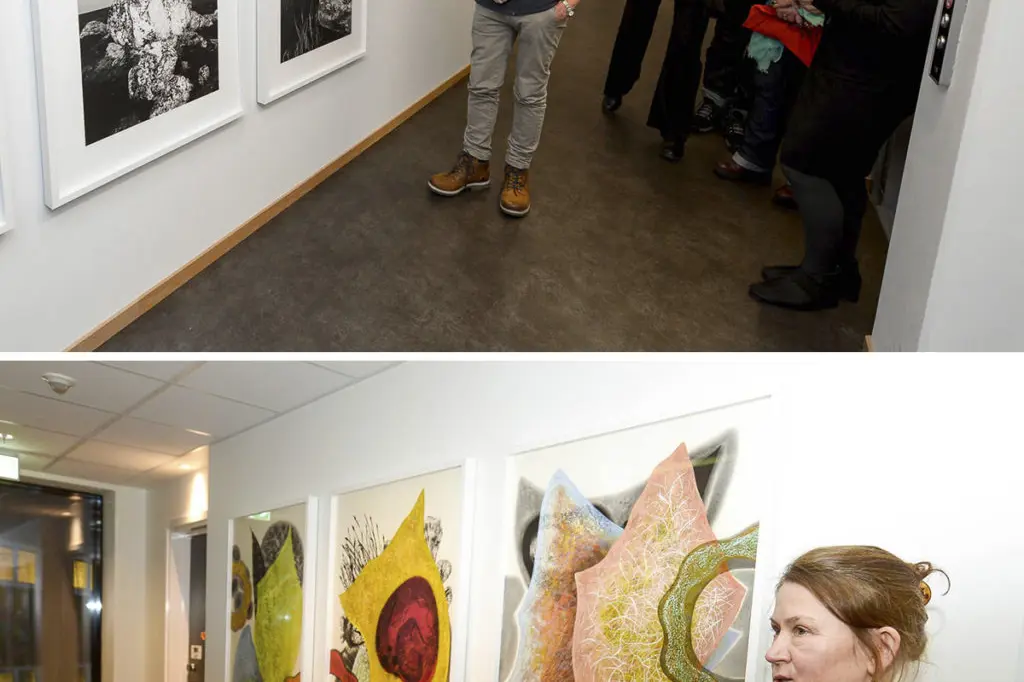 En gruppe mennesker som ser på kunst på en vegg
