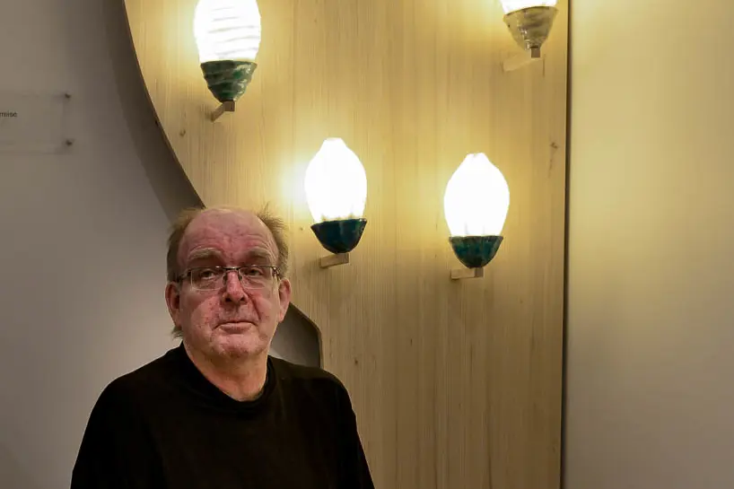 En mann som sitter på gulvet med en gruppe lys over seg