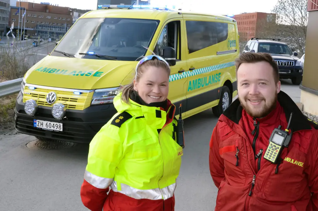 En mann og kvinne som poserer foran en gul varebil