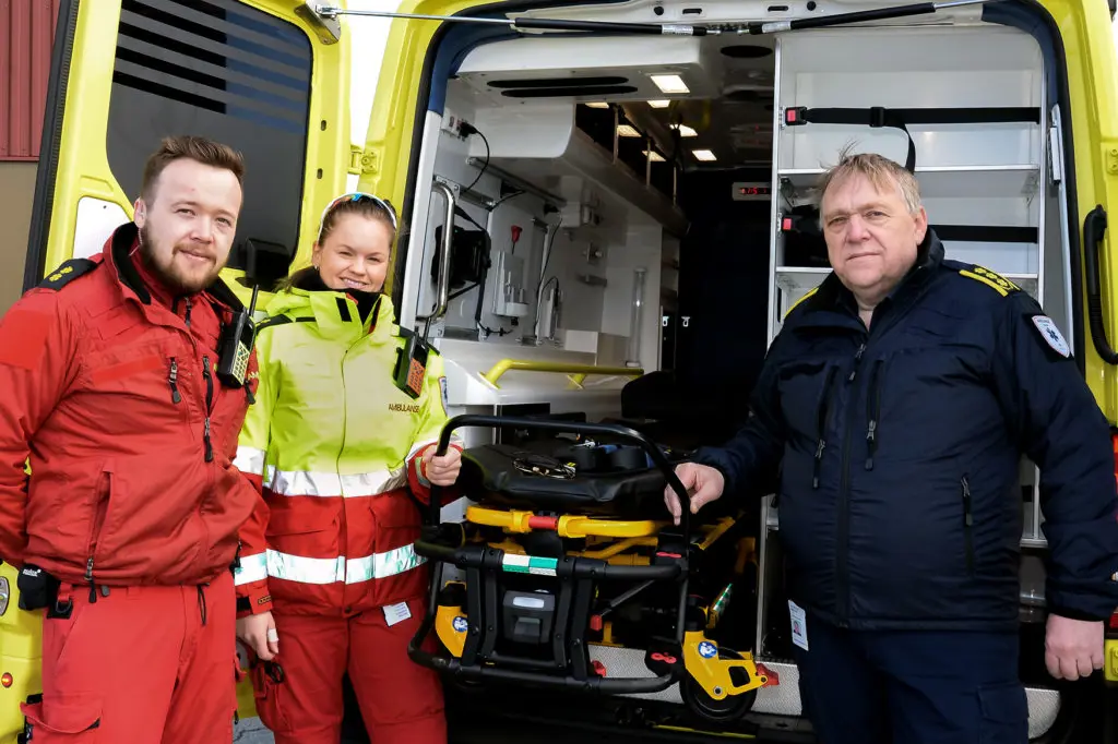 En gruppe mennesker som står ved siden av en bil