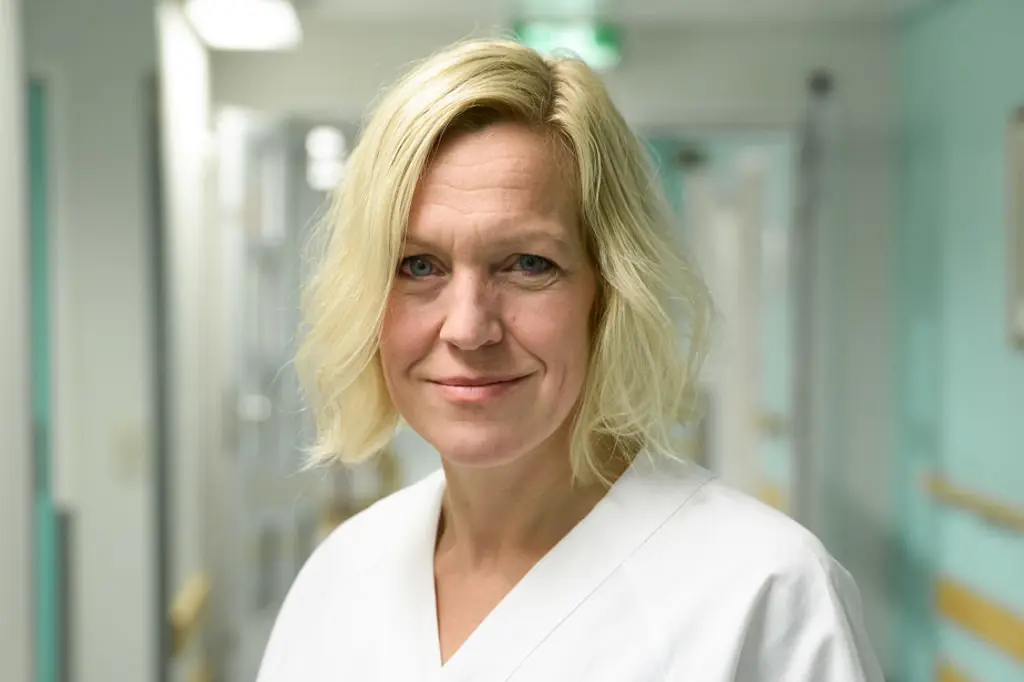 En kvinne som smiler til kameraet