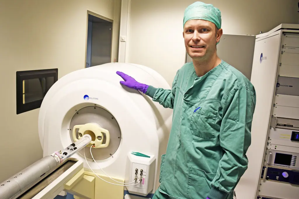 En person i laboratoriefrakk som holder en hvit gjenstand