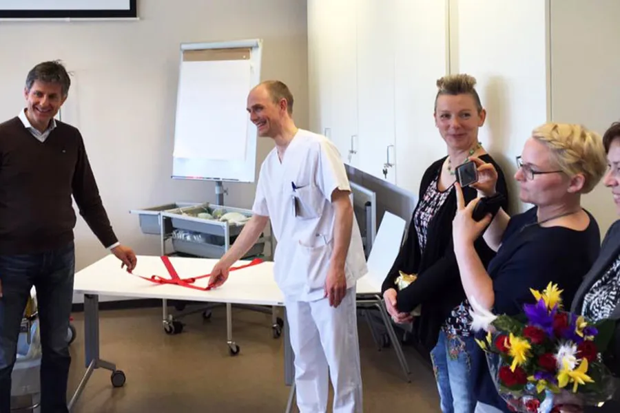 En gruppe mennesker som står rundt en person som spiller piano