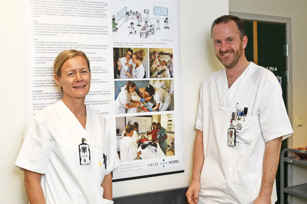 En mann og en kvinne som står foran en plakat