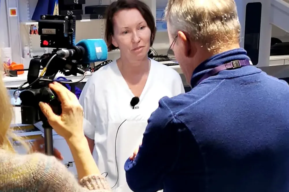 En kvinne som tar et bilde av en mann i hvit frakk