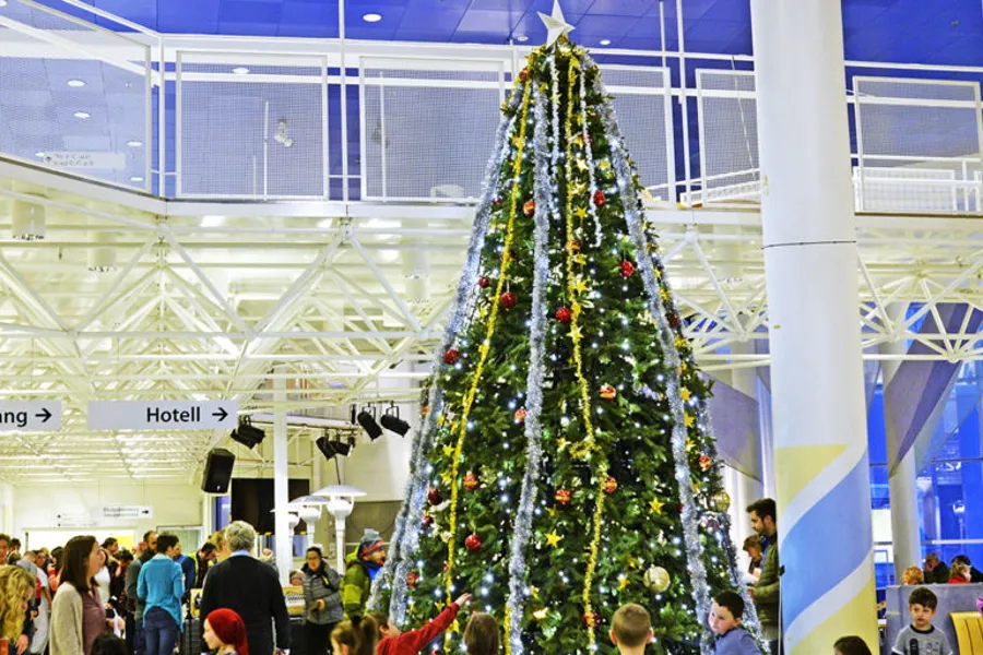 En stor folkemengde i en stor bygning med juletre